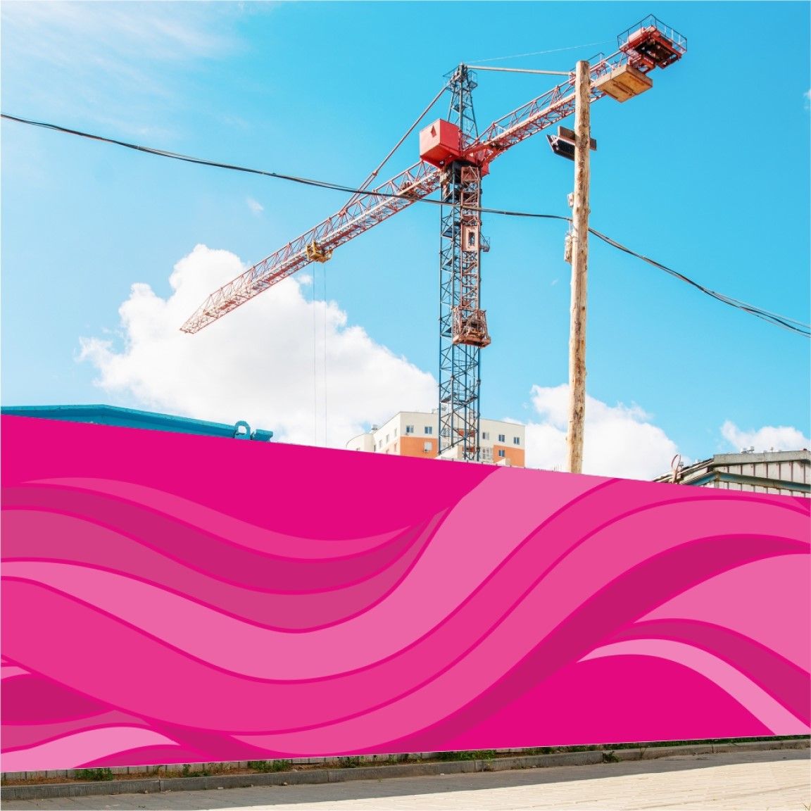 A printed hoarding board installed along a construction site boundary, displaying large-format graphics while a crane is visible in the background