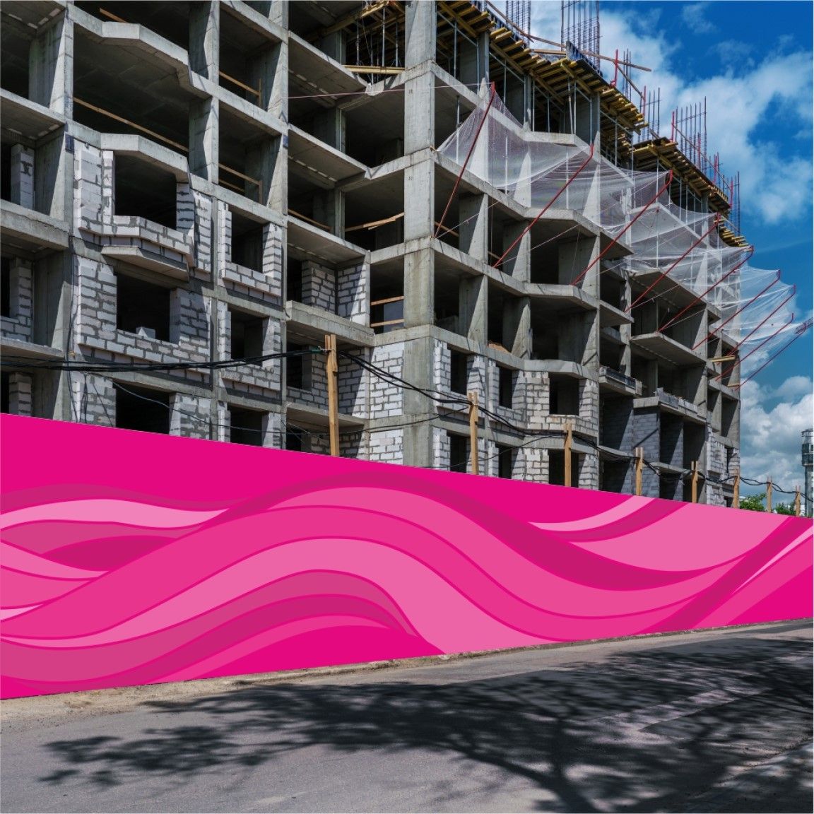 A printed hoarding board installed along a development site boundary, displaying large-format graphics.