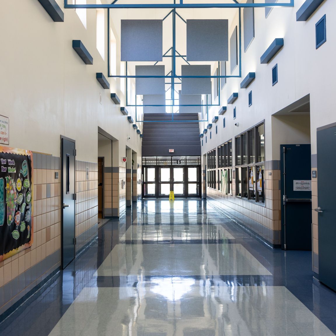 School hallway featuring colourful printed posters and educational displays along the walls.