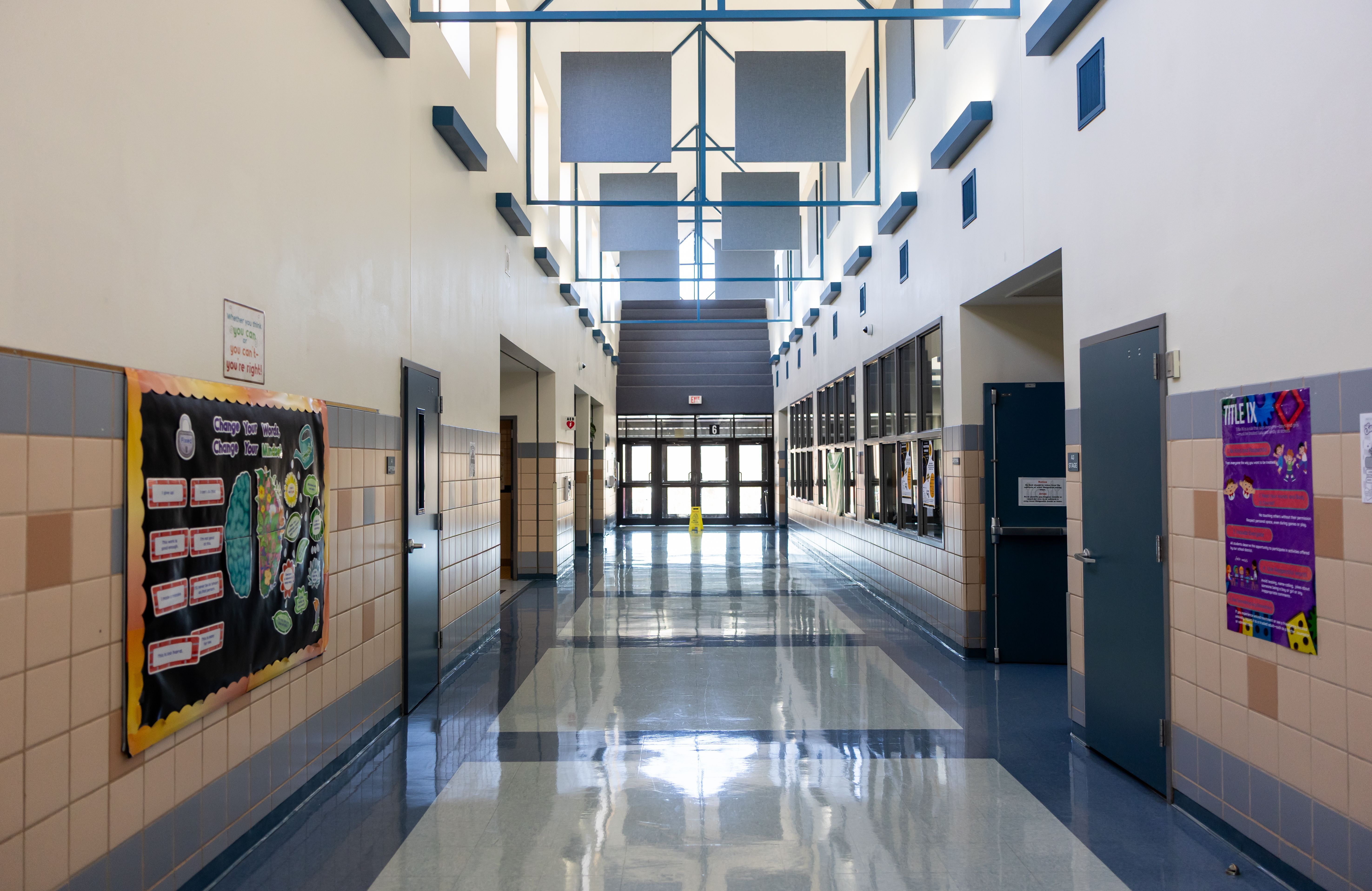 School hallway featuring colourful printed posters and educational displays along the walls.