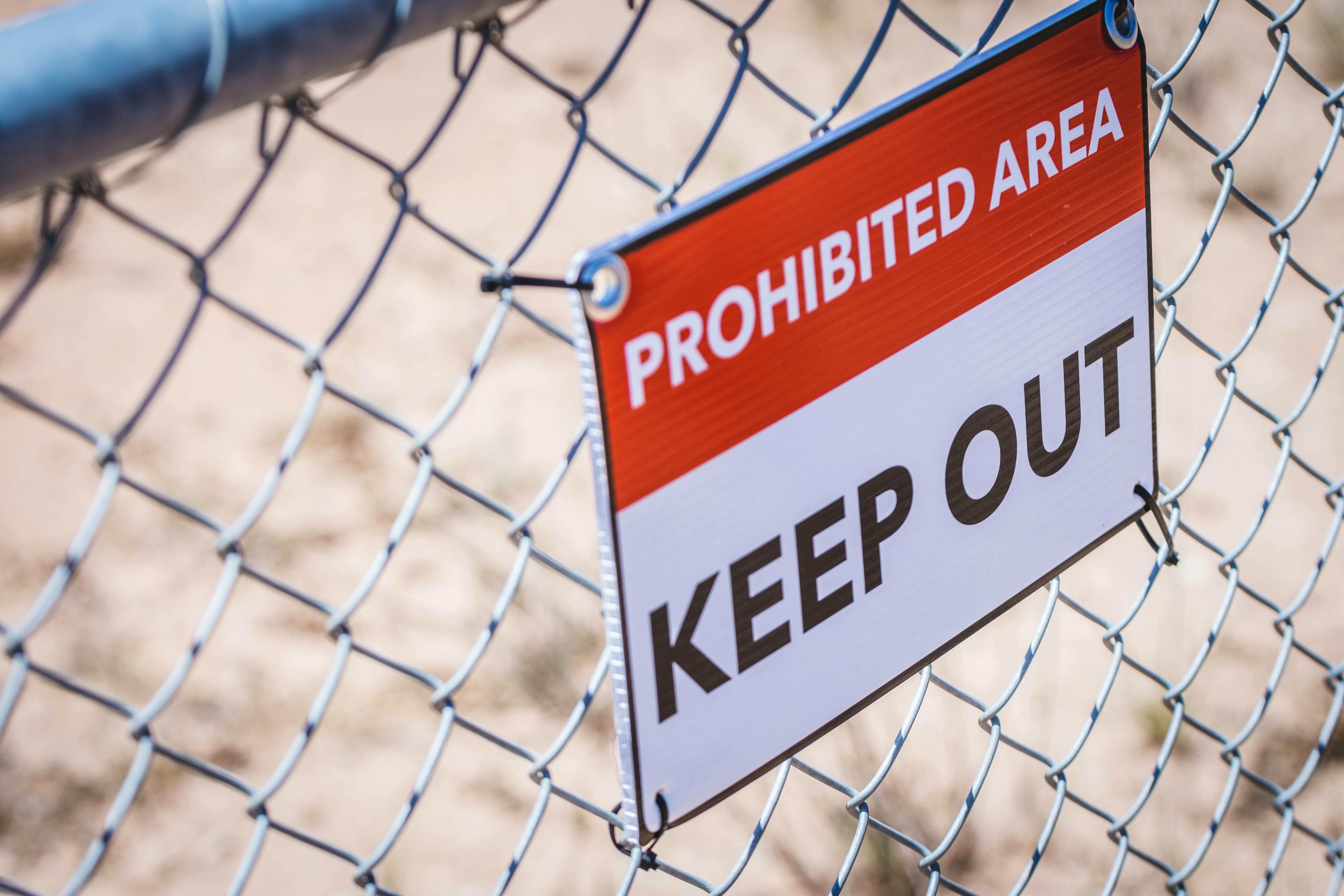 Construction site fencing covered with large Foamex panels showcasing branding, safety messaging, and promotional graphics.