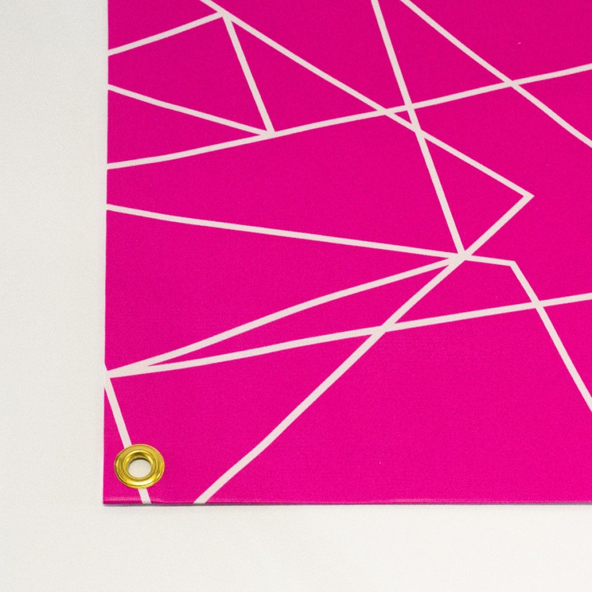 A close-up of a PVC banner showing the smooth printed surface, reinforced hem and metal eyelet for secure installation, suitable for outdoor event signage and festival use.